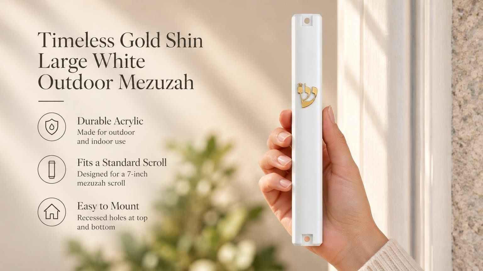 A hand holding a white mezuzah cover with a gold-tone crowned Shin and clipped corner design.