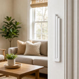 Indoor lifestyle scene showing the modern white pyramid mezuzah mounted on a residential doorpost, with a view into the room.