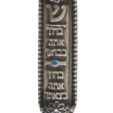 Petite Moroccan style pewter Mezuzah with Hebrew blessing, suitable for home doorways, featuring intricate details and placed on a white studio surface.