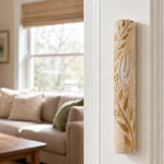 Jerusalem stone mezuzah mounted vertically on a residential doorpost in a natural indoor setting, showcasing its elegant design and materials.