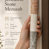 Person holding the Jerusalem stone mezuzah in a premium editorial style with warm natural light and balanced composition.