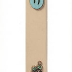 Light blue wooden baby boy mezuzah with silver shoes and blue sequins for doorpost decoration, displayed vertically against a white studio background with soft reflection.