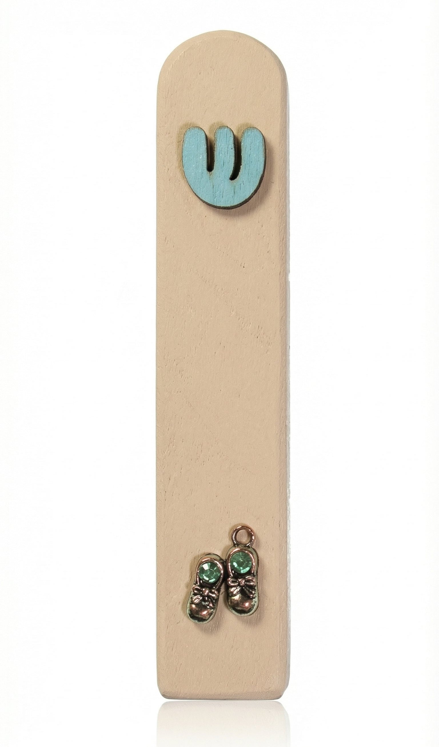 Light blue wooden baby boy mezuzah with silver shoes and blue sequins for doorpost decoration, displayed vertically against a white studio background with soft reflection.