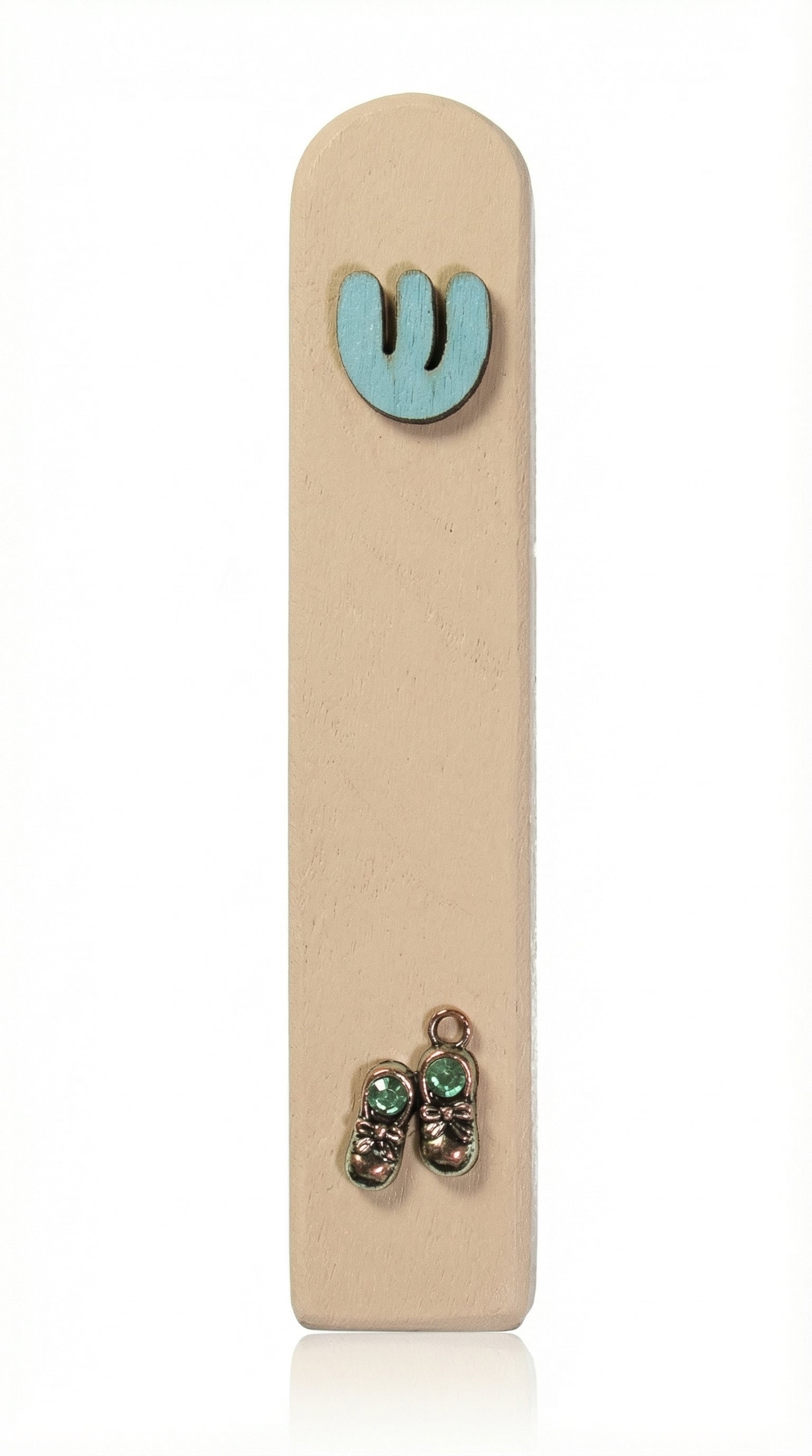 Light blue wooden baby boy mezuzah with silver shoes and blue sequins for doorpost decoration, displayed vertically against a white studio background with soft reflection.