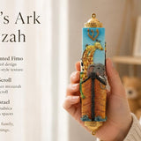 Hand-held Noah’s Ark Mezuzah showing colorful children’s Judaica with animal designs and soft blue background, designed for nurseries and kids' rooms.
