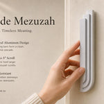 Person holding the Nova Silver Cascade Mezuzah showing its architectural aluminum design and dimensions in a lifestyle setting.