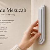 Person holding the Nova Silver Cascade Mezuzah showing its architectural aluminum design and dimensions in a lifestyle setting.