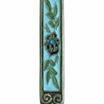 Hand-painted pewter Mezuzah with olive branches, crystal center, and intricate details on white background with soft reflection.