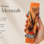 Hand holds the vibrant orange violin-themed mezuzah with detailed ceramic texture, showcasing its musical motif perfect for music lovers.