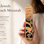 Peach enamel mezuzah case with dove, floral accents, and jeweled panel, featuring a Hebrew Shin and leafy branches, made in Israel.