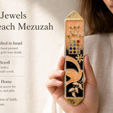 Peach enamel mezuzah case with dove, floral accents, and jeweled panel, featuring a Hebrew Shin and leafy branches, made in Israel.