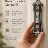 Pearlescent Kotel Heart brown pewter mezuzah being placed on a white doorpost with silver Shin and heart-shaped Star of David details