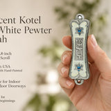 Hand holding Pearlescent Kotel Heart white pewter mezuzah case with silver Shin, blue accents and heart-shaped Stars of David
