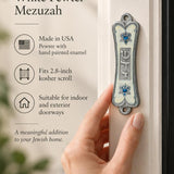 Pearlescent Kotel Heart white pewter mezuzah being placed on a doorway with raised Shin, blue accents and heart-shaped Star of David designs