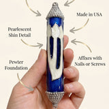 Person supporting a Heavenly Blue mezuzah, emphasizing its elegant design, material, and craftsmanship in a clean, minimalist style.
