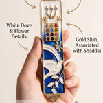 Person holding a dove blue mezuzah showcasing its detailed design and elegance.