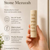 Person holding Jerusalem stone mezuzah horizontally, showcasing its texture and design with natural light and detailed focus.