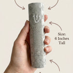 Person holding Jerusalem stone mezuzah in hand, emphasizing material and craftsmanship.