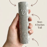 Person holding Jerusalem stone mezuzah in hand, emphasizing material and craftsmanship.