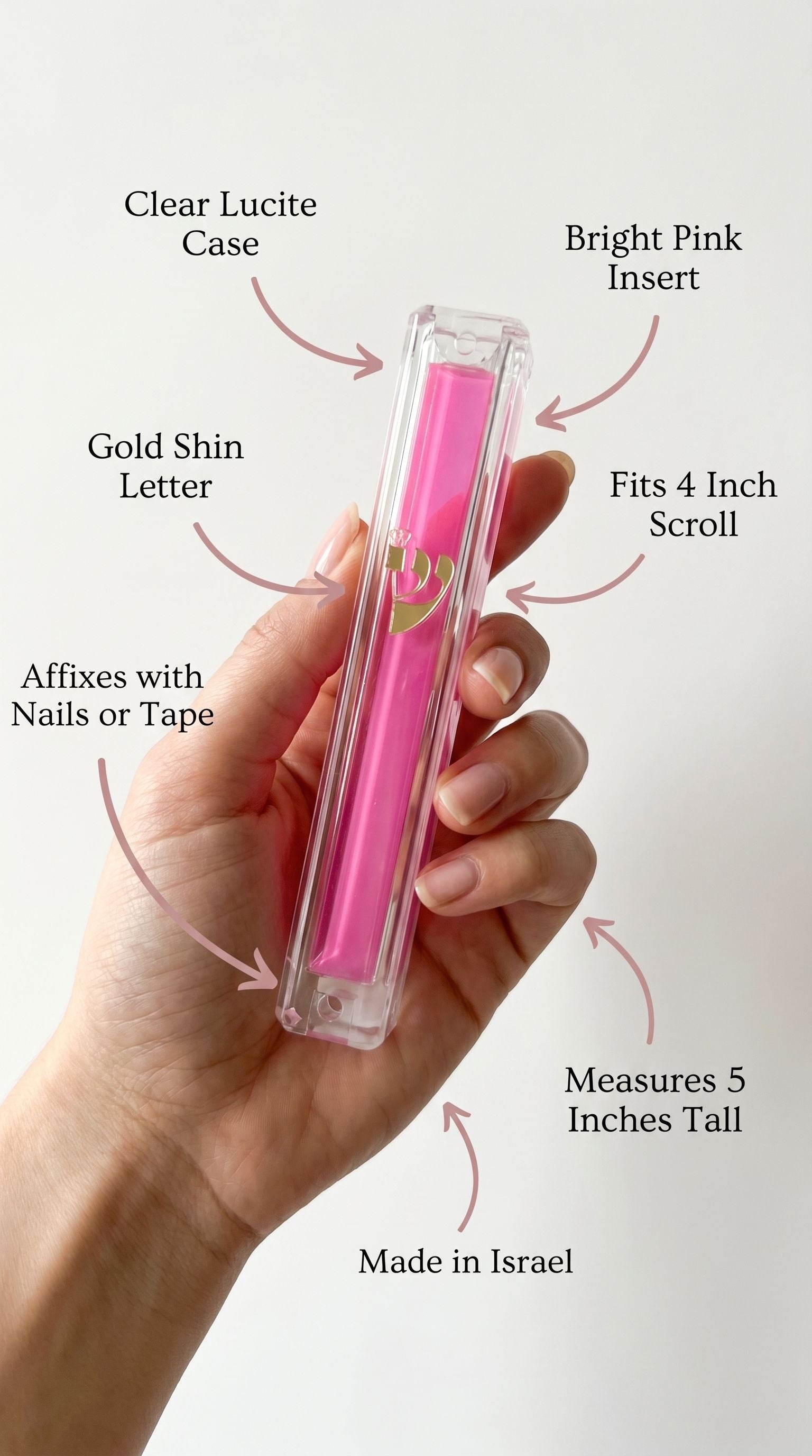 Person holding a clear pink Lucite Mezuzah display emphasizing its material, size, and mounting features for home placement.