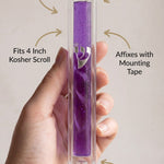Close-up of hand holding purple lucite mezuzah, showcasing material, size, and mounting details.