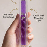 Close-up of hand holding purple lucite mezuzah, showcasing material, size, and mounting details.