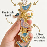 Close-up of a hand holding the Shalom Birds Mezuzah, emphasizing its material, size, and detailed design for a callout image.