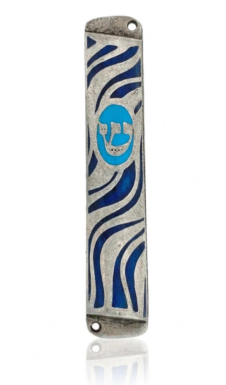 Petite pewter finish mezuzah case with Hebrew letters, decorative motifs, and smooth curves, displayed on a white studio surface with a subtle reflection.