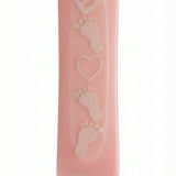Pink glass mezuzah decorated with adorable baby feet design, displayed on a white background with soft reflection for an elegant look.