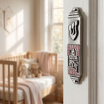 Pink pewter mezuzah with enamel accents mounted on the right side of an elegant interior doorway in a home setting.
