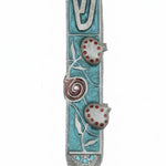 High-resolution image of a hand-painted pewter Mezuzah with pomegranate design on a pure white background, including a soft reflection.