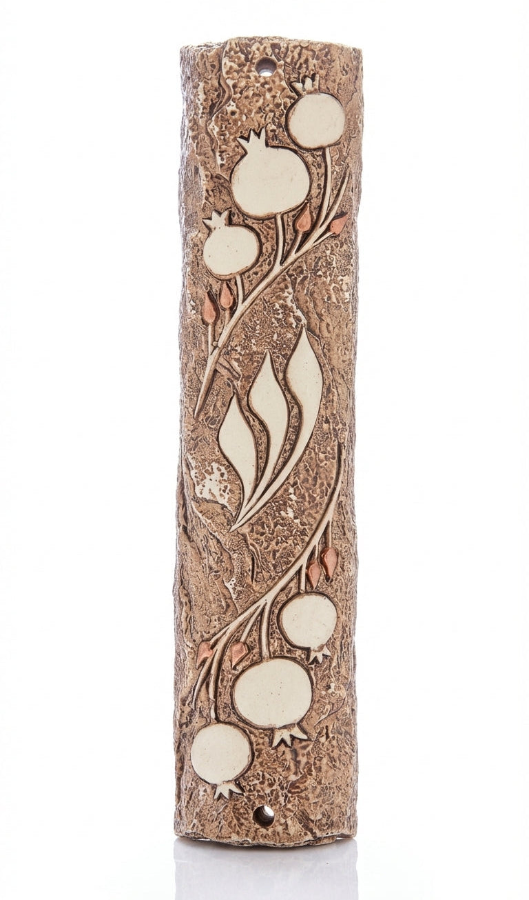 Detailed pomegranate motif Mezuzah designed by Israeli artist, symbolizing Jewish tradition and filled with Mitzvot, on a bright white background with soft reflection.