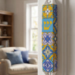 Ceramic Portugal mezuzah with blue and yellow colors, mounted on an indoor doorway for Jewish home blessing.