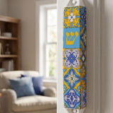 Ceramic Portugal mezuzah with blue and yellow colors, mounted on an indoor doorway for Jewish home blessing.