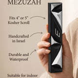 Hand-held black aluminum mezuzah with Hebrew scroll, showcasing detailed contours and traditional design.