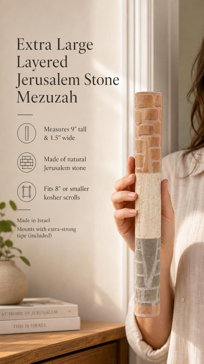 Close up of a hand holding an extra large layered Jerusalem stone mezuzah case with natural beige textures.