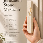 Individual displaying Jerusalem stone mezuzah with warm natural lighting and neutral palette highlighting product details.