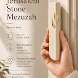 Individual displaying Jerusalem stone mezuzah with warm natural lighting and neutral palette highlighting product details.
