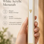 A person holding the gold and white acrylic mezuzah case, designed to fit a standard five-inch kosher parchment scroll.