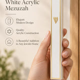 A person holding the gold and white acrylic mezuzah case, designed to fit a standard five-inch kosher parchment scroll.