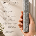 Person naturally holding the Jerusalem stone mezuzah, highlighting its texture and size for a product feature display.