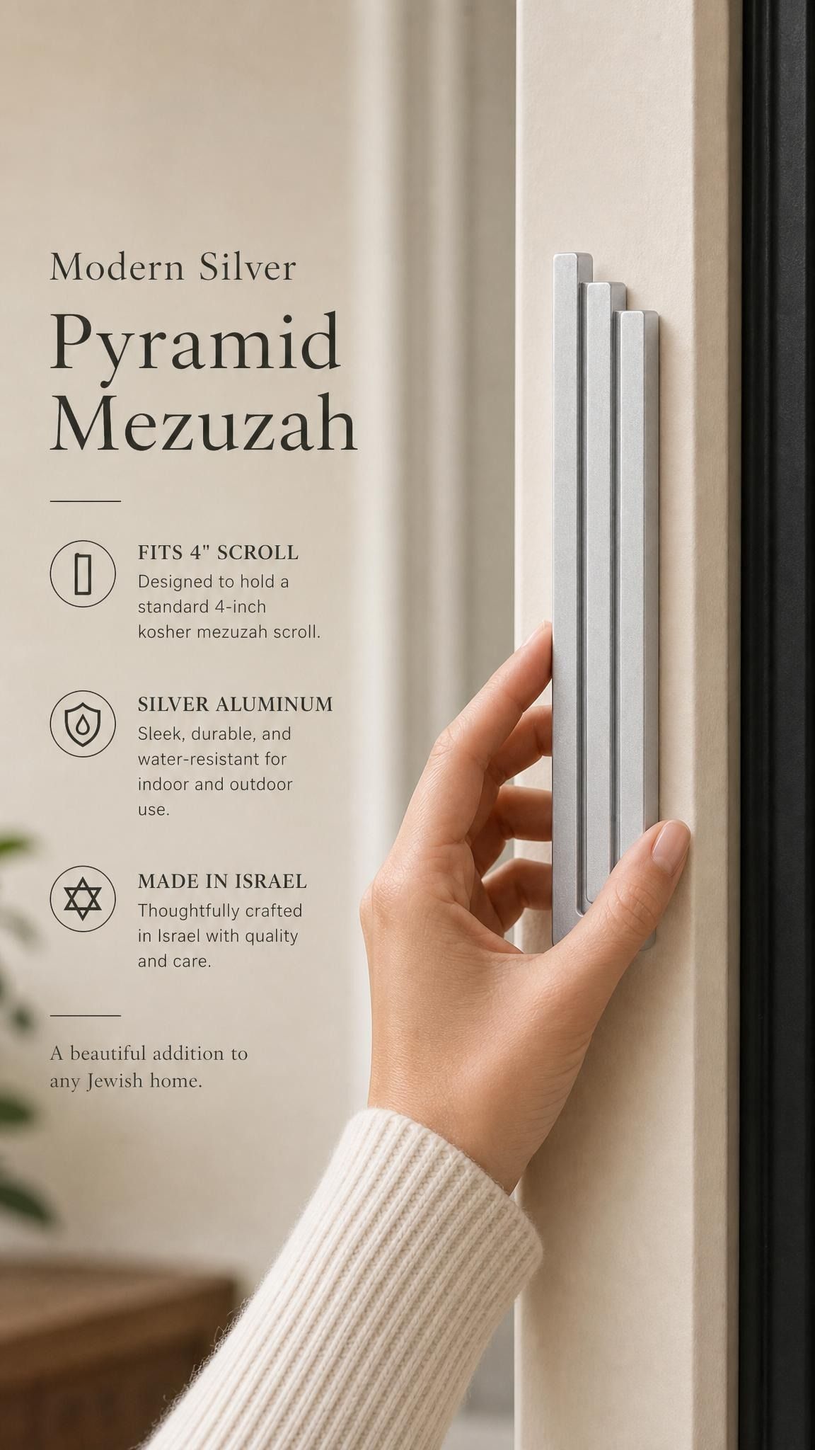 Person holding the exact modern silver pyramid mezuzah against a neutral background, demonstrating its size and design.