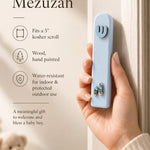Person holding the exact light blue wooden mezuzah in a premium store setting, showcasing its details and craftsmanship.