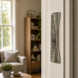 Jerusalem pewter mezuzah mounted vertically on a residential doorpost in a natural indoor setting, showing accurate placement and scale.