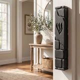 Lifestyle image of a home interior featuring a black cement mezuzah mounted on the doorpost in a well-lit, inviting room setting.
