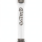 Regal Crown Pewter and Clear Acrylic Mezuzah shown from the front as a mezuzah cover featuring a transparent acrylic chamber framed by silver-toned pewter crown ends, dark recessed decoration and curling silver scrollwork down the front, presenting a detailed Judaica design for a Jewish home doorway