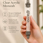 Handheld portrait of the Regal Crown Pewter and Clear Acrylic Mezuzah mezuzah cover, with a transparent acrylic chamber framed by silver-toned pewter crown ends, dark recessed details and curling front scrollwork clearly visible beside the product name and illustrated features of this distinctive Jewish doorway design