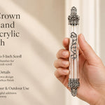 Regal Crown Pewter and Clear Acrylic Mezuzah mezuzah cover held upright in one hand, showing a transparent acrylic chamber framed by silver-toned pewter crown ends, dark recessed decoration and curling silver scrollwork down the front beside the product name and illustrated design features in a wide social-sharing graphic for decorative Jewish home Judaica