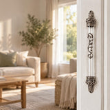 Regal Crown Pewter and Clear Acrylic Mezuzah mounted vertically on a pale home doorpost, with a transparent acrylic chamber framed by silver-toned pewter crown ends, dark recessed decoration and curling silver scrollwork down the front creating a distinctive mezuzah cover that brings its Jewish design and decorative detail into the doorway