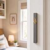 Vertical mounted Slim charcoal gray mezuzah case with gold three-part eternal flame and stylized Shin on right doorpost